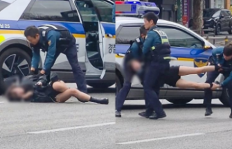 Scene halucinante în Seul: o femeie, cărată de trei polițiști după ce s-a întins pe o șosea aglomerată
