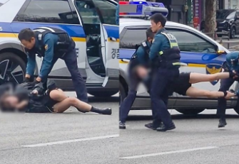 Scene halucinante în Seul: o femeie, cărată de trei polițiști după ce s-a întins pe o șosea aglomerată